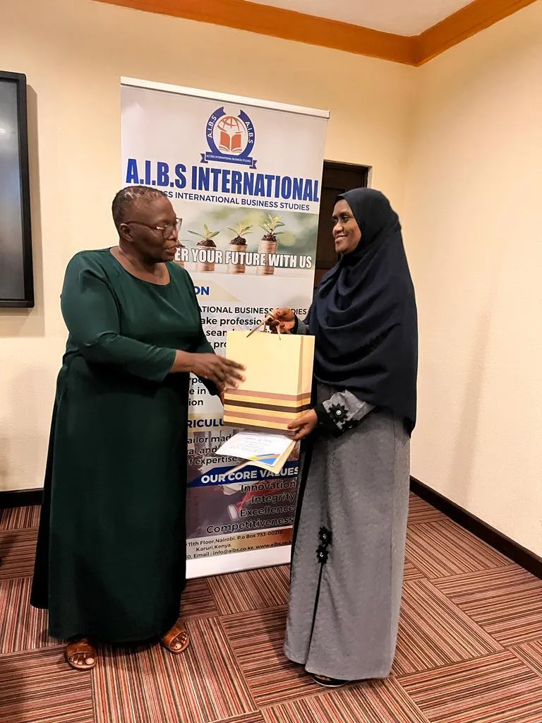 Presenting a gift bag and certificate to a participant at an AIBS training