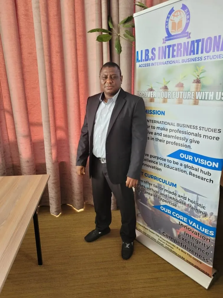 Trainer standing beside the AIBS International banner